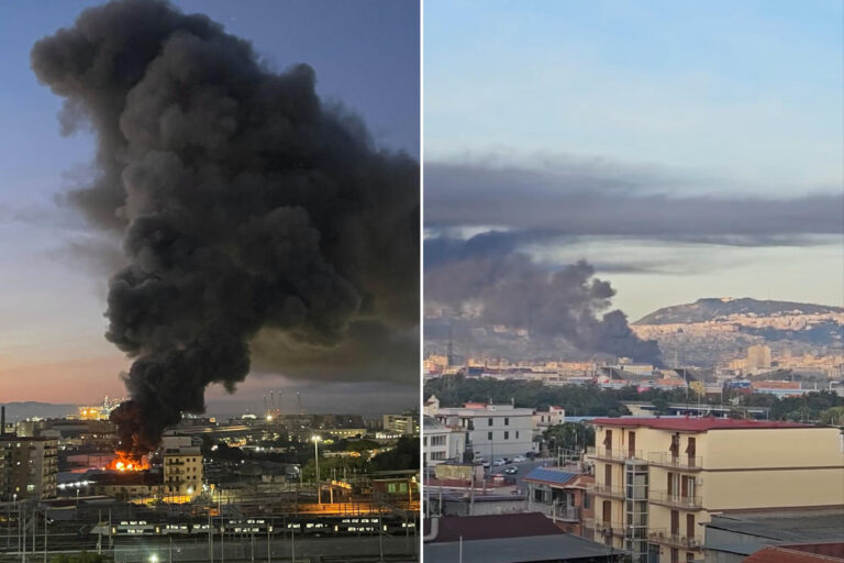 Immense incendie à Naples : entrepôt en feu et dense colonne de fumée noire visible à travers le Golfe